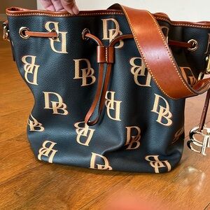 Dooney and bourke drawstring  handbag. Gently pre loved. Black w/ gold and brown